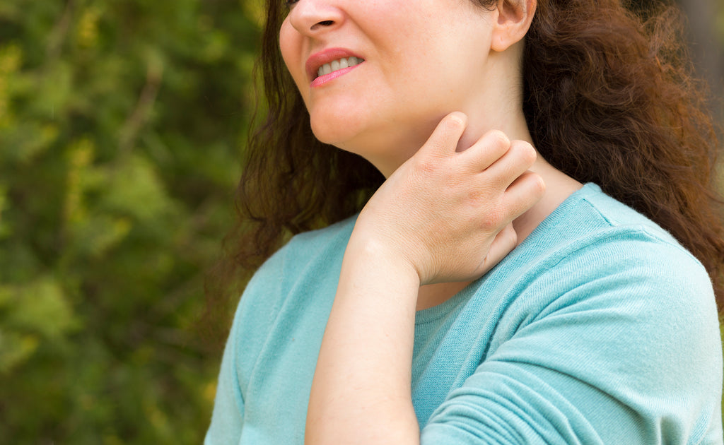 woman scratching her neck after exposure to allergen in spring